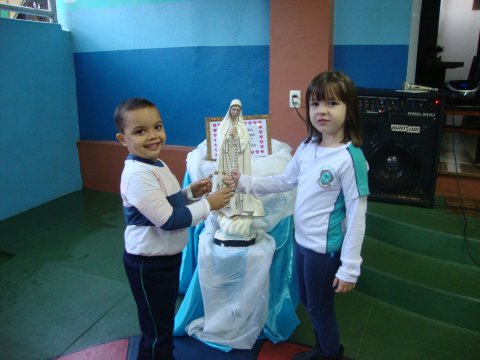 Os Pequenos da Educação Infantil rezam e cantam para Mãezinha do Céu.